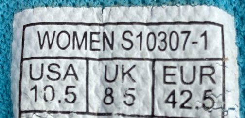 Ein Etikett auf der Rückseite eines Pullovers mit der Aufschrift „Women's s1030-1“.